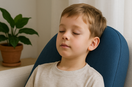 A child with autism peacefully experiencing vibroacoustic therapy through a specialized cushion emitting 40Hz frequencies