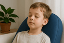 A child with autism peacefully experiencing vibroacoustic therapy through a specialized cushion emitting 40Hz frequencies