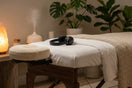 A wooden massage table converted into a DIY vibroacoustic bed using tactile sound healing transducers attached underneath the frame